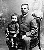 Photograph of Ludwig Struve sitting on a chair with his young son Otto on his knee