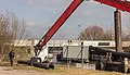 Tijdelijke pijpleidingen worden door een Komatsu kraan PC450LC vanaf motorvrachtschip Hector overgeladen.