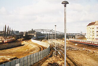 A S-Bahn train of the Reichsbahn (right) runs from Schönhauser Allee on the connecting line to Pankow, west of the Wall a S-Bahn train of the BVG (left) goes to Gesundbrunnen (1990).