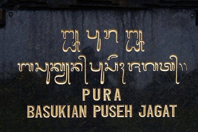 A sign in Balinese and Latin script at a Hindu temple in Bali