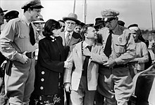 Helen (Barbara Bates) with Dan when captured by police; behind them, wearing glasses, is the lawyer Harvey (Taylor Holmes) Barbara Bates-Mickey Rooney in Quicksand.jpg