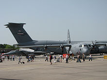 Eine Lockheed C-130 Herkules und das Heck einer Lockheed C-5 Galaxy (links im Hintergrund sind zwei F-15E Strike Eagles)