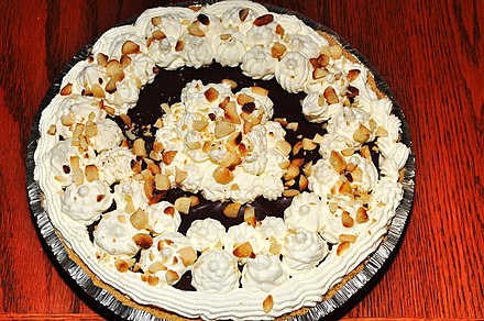 A chocolate cream pie with a graham cracker crust and macadamia nuts