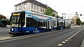 Dresdner Verkehrsbetriebe - Straßenbahn Linie 10 Messe Dresden mit Sonderbeklebung - Oppacher Mineralquellen - Hintergrund Pentacon Werke Dresden