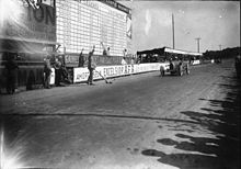 Photographie d'une voiture franchissant la ligne d'arrivée.