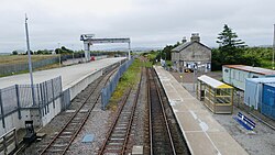 The platform and freight terminal at Georgemas Junction station, looking west towards Inverness; the branch to Thurso can be seen diverging off the main line to the right immediately beyond the platform. Georgemas.jpg