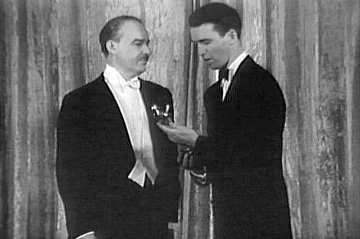 Alfred Lunt overhandigt James Stewart de Oscar voor beste acteur.
