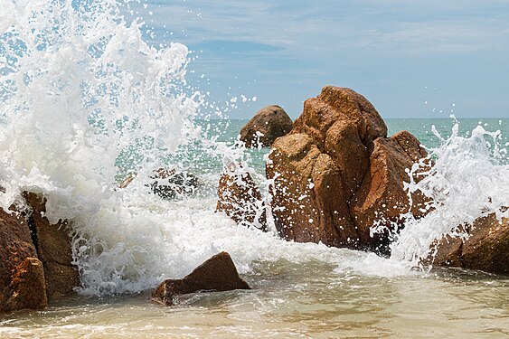 Waves breaking on rocks at Teluk Cempedak beach, Malaysia