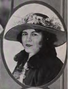 A white woman with dark hair, wearing a hat with a wide brim, in an oval frame