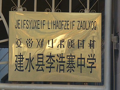 Lihaozhai High School in Jianshui, Yunnan. The sign is in Hani (Latin alphabet), Nisu (Yi script), and Chinese.