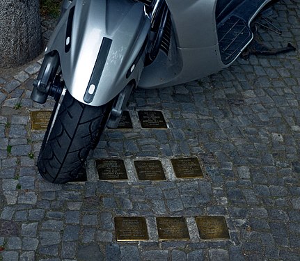 Holocaust victims do not have graves, but modern residents have parking for motor scooters. Memorial tablets near the house where the victims of the Holocaust lived. Berlin