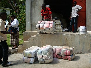 Bales of used clothing being unloaded from a warehouse in Haiti Pepe in bales.jpg