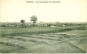 Derrière ce champ moissonné, une vue panoramique des lotissements de Stains (avant 1920).