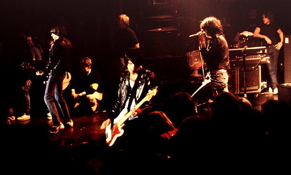 Members of the seminal punk rock band Ramones wearing early punk fashion items such as Converse sneakers, black leather jackets, and blue jeans