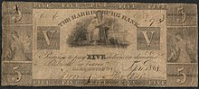 Five dollar bill. The illustration includes female figure with a rake and grain; and a seated Justice with sword and scales. The inscription reads Inscription: "THE HARRISBURG BANK Promises to pay FIVE dollars on demand to ___ or bearer."