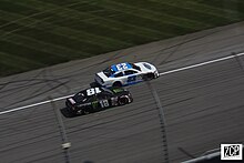 Holmes racing Riley Herbst (No. 18) at Kansas in July 2020. Holmes would go on to win this race. Riley herbst bret holmes (50212488657).jpg