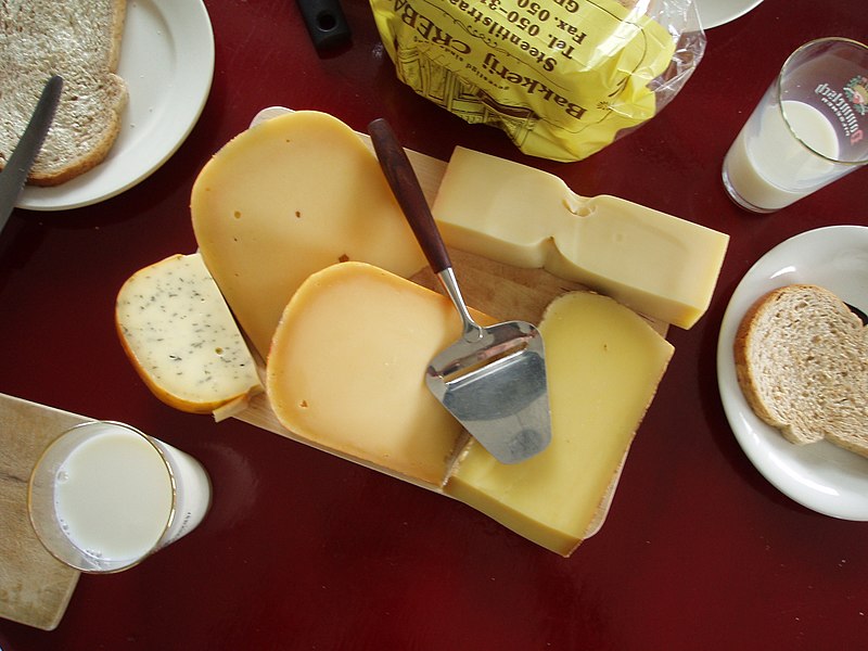 File:Several cheeses with a slicer, bread and milk.JPG