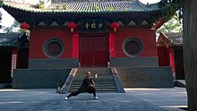 A monk practicing Shaolin Kung Fu in front of a hall in the Shaolin Monastery in Henan Shaolin templo.jpg