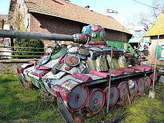 Sculpture d'art brut représentant un tank dans le jardin de la ferme vanabelle