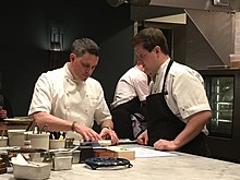 Chef Kaysen preparing food at his restaurant Demi with chef de cuisine Adam Ritter in April 2019. 2019-0413-GavinKaysen-Demi.JPG