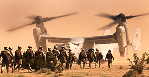 חיילי מארינס עושים דרכם לעבר כלי טיס מסוג בל-בואינג V-22 אוספריי.