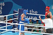 Deutsch: Boxen bei den Olympischen Jugendspielen 2018 Tag 12, 18. Oktober 2018 - Kampf um Bronze im Leichten Weltergewicht Jungen – Hassan Azim (Großbritannien, rot) schlägt Mohammed Boulaouja (Marokko, blau) RSC; Ringrichter ist Wulfren Olivares Peréz (Kolumbien). English: Boxing at the 2018 Summer Youth Olympics on 18 October 2018 – Bronze Medail Match Light Welterweight Boys - Hassan Azim (Great Britain, red) beats Mohammed Boulaouja (Morocco, blue) RSC; Referee is Wulfren Olivares Peréz (Columbia). Español: Boxeo en los Juegos Olímpicos Juveniles de Verano de 2018 en 18 de octubre de 2018 - Medalla de bronce de los hombres ligeros de peso welter: Hassan Azim (Gran Bretaña, rojo) vence a Mohammed Boulaouja (Marruecos, azul) RSC; El árbitro es Wulfren Olivares Peréz (Colombia).