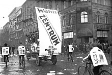Large Centre Party banner and bicyclists wearing signs