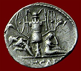Roman Denarius circa 46-45 BC, depicting a trophy of arms tropaion from the Gallic Wars of Julius Caesar showing a captured Gaul on one side and a mourning female symbolizing Gallia, defeated, on the other