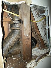 This view looking upwards through a hole in the ceiling shows a traditional leaded hub joint (at top) and a more recent rubber-sleeved hubless connection (at lower right). Cast-iron plumbing pipe.jpg