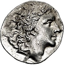 Photo of an ancient coin shows a clean-shaven man with wavy hair.