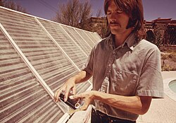 Photo of Meinel's son Walter demonstrates a solar heating panel being used to heat the swimming pool of the family home