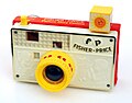 Jouet appareil photo en bois et plastique de 1967. Le viseur présente 8 vues qui changent en pressant le déclencheur.