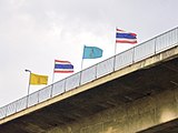 Queen Sirikit's flag with the king's flag and the flags of Thailand.