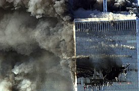 Północna ściana płonącej Wieży Północnej WTC z widoczną wyrwą po uderzeniu lotu 11 linii American Airlines