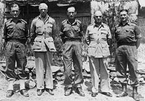 Portrait en pied de cinq hommes en uniforme militaire.