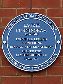 Blue plaque for Laurie Cunningham, outside Brisbane Road Laurie Cunningham 1956-1989 football legend pioneering England International played for Leyton Orient FC 1974-1977.jpg