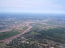 Moncton is located along the north bank of the Petitcodiac River, at a point where the river bends acutely from a west-east to north-south flow. Moncton aerial 3847.jpg