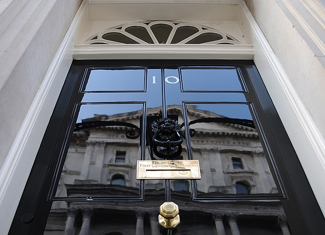 The front door of 10 Downing Street, showing the letter-box inscribed with "First Lord of the Treasury"