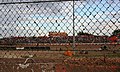 View of main grandstand from backstraight through clay on the crash fence.