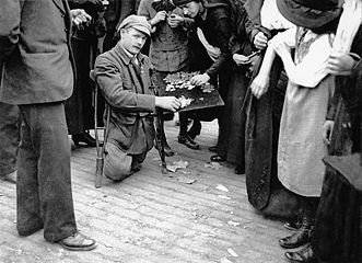 Mutilé de guerre vendant des insignes lors du défilé du 14 juillet 1919.