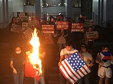 Student activists from University of the Philippines and Ateneo de Manila University burn the flags of China and US to protest against their encroachment of Philippine sovereignty. Protest Mobilization Against State Visit of Xi Jinping US-China Flag Burning by Students from University of the Philippines Diliman and Ateneo de Manila.jpg
