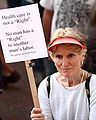 Woman outside the West Hartford, Connecticut town hall after a health care reform town hall meeting with U.S. Representative John B. Larson on 2 September 2009, holding a sign that reads: with a sign that reads: :Health care is not a "Right". :No man has a "Right" to another man's labor. :The ghosts of Gettysburg