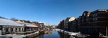 The view north from Redcliffe Bridge, showing two yellow water taxis, warehouses and various buildings along Welsh Back