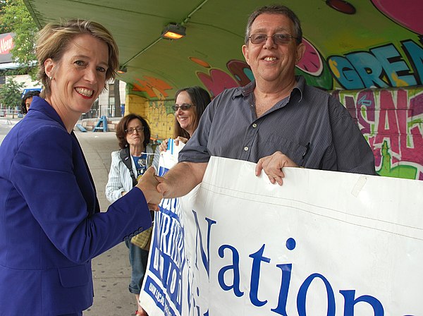 Teachout shaking hands with National Writers Union (UAW Local 1981) president Larry Goldbetter at the "We Will Not Go Back" march and rally held on Au