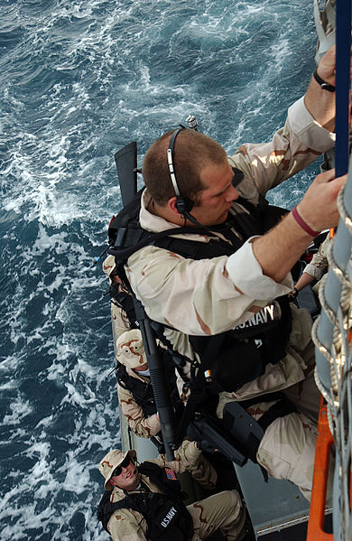 File:US Navy 050413-N-5526M-002 Damage Controlman 2nd Class Christopher Duffin climbs up the side of the Arleigh Burke-class guided missile destroyer USS Mustin (DDG 89) after completing Maritime Security Operations.jpg