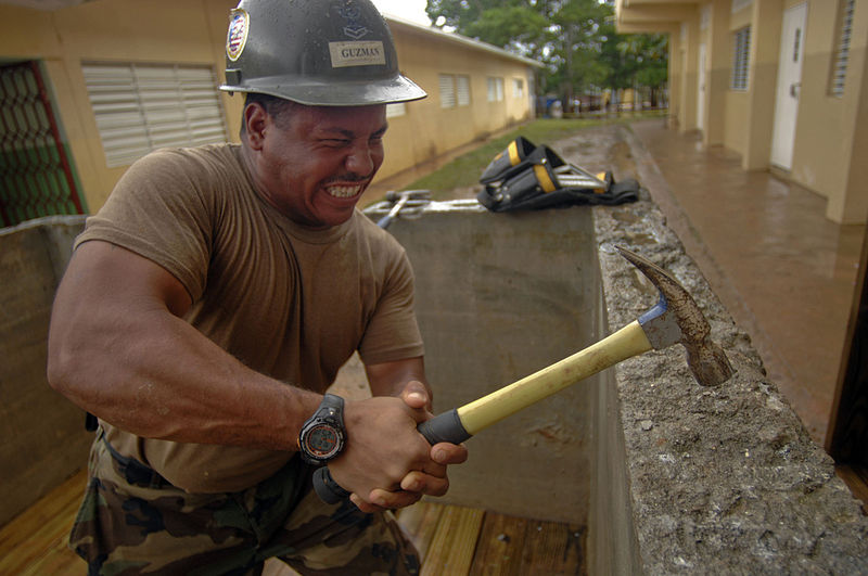 File:US Navy 081013-N-9620B-003 Equipment Operator 2nd Class Carlos Guzman, aboard the amphibious assault ship USS Kearsarge (LHD 3), levels the surface for a gazebo to expand the school Presbitero Carlos Novel.jpg