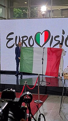 The Ambassador of Italy to Serbia, Carlo Lo Cascio, presenting the flag of the host country of the Eurovision Song Contest 2022 to Konstrakta VideoCapture 20220428-193828.jpg