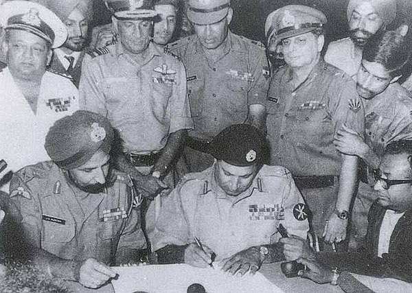 Pakistan's Lt. Gen. A. A. K. Niazi signing the instrument of surrender in Dhaka on 16 Dec' 1971, in the presence of India's Lt. Gen. J.S. Aurora. Standing behind them are officers of India's Army, Navy and Air Force. The 1971 War directly involved participation of all three arms of Indian Armed Forces.