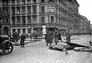 Berlínská policie demontuje barikádu postavenou demonstranty.