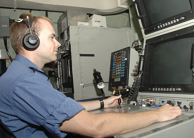 A sonar operator training on sonar equipment aboard HMCS Calgary.